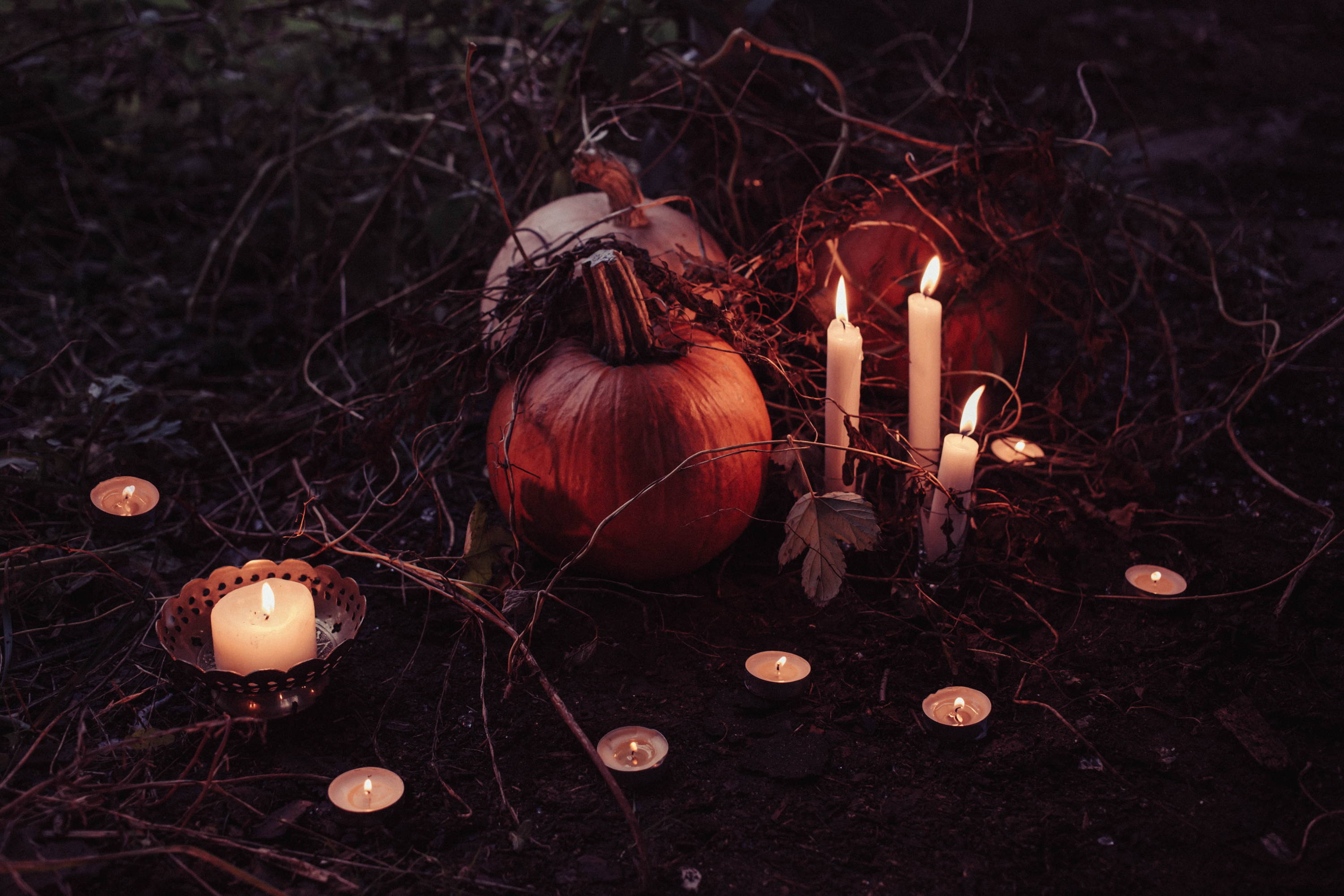 pumpkin in centre with candles surrounding for halloween and gift