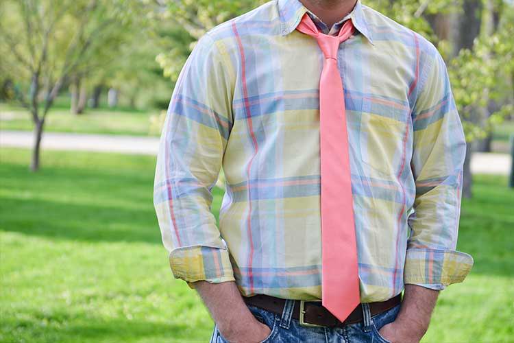 Man wearing a plaid shirt, jeans and coral skinny tie