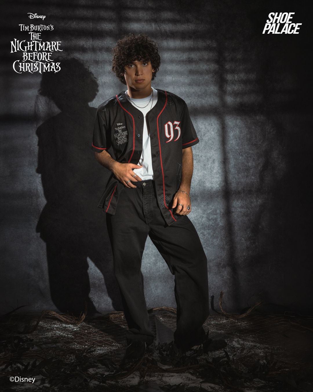 A person wearing a baseball jersey stands in a shadowy environment.