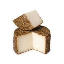 A wedge of cheese with a textured rind and smooth interior.