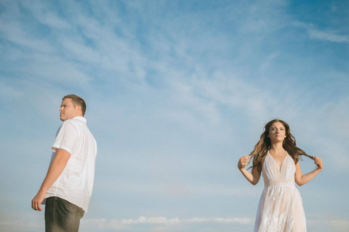 Quinn and Lakin engagement photo looking off into the distance with blue sky