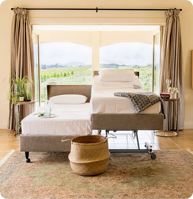 Adjustable bed shown at a low height in a bright bedroom, supporting easier transfers and safer daily use.