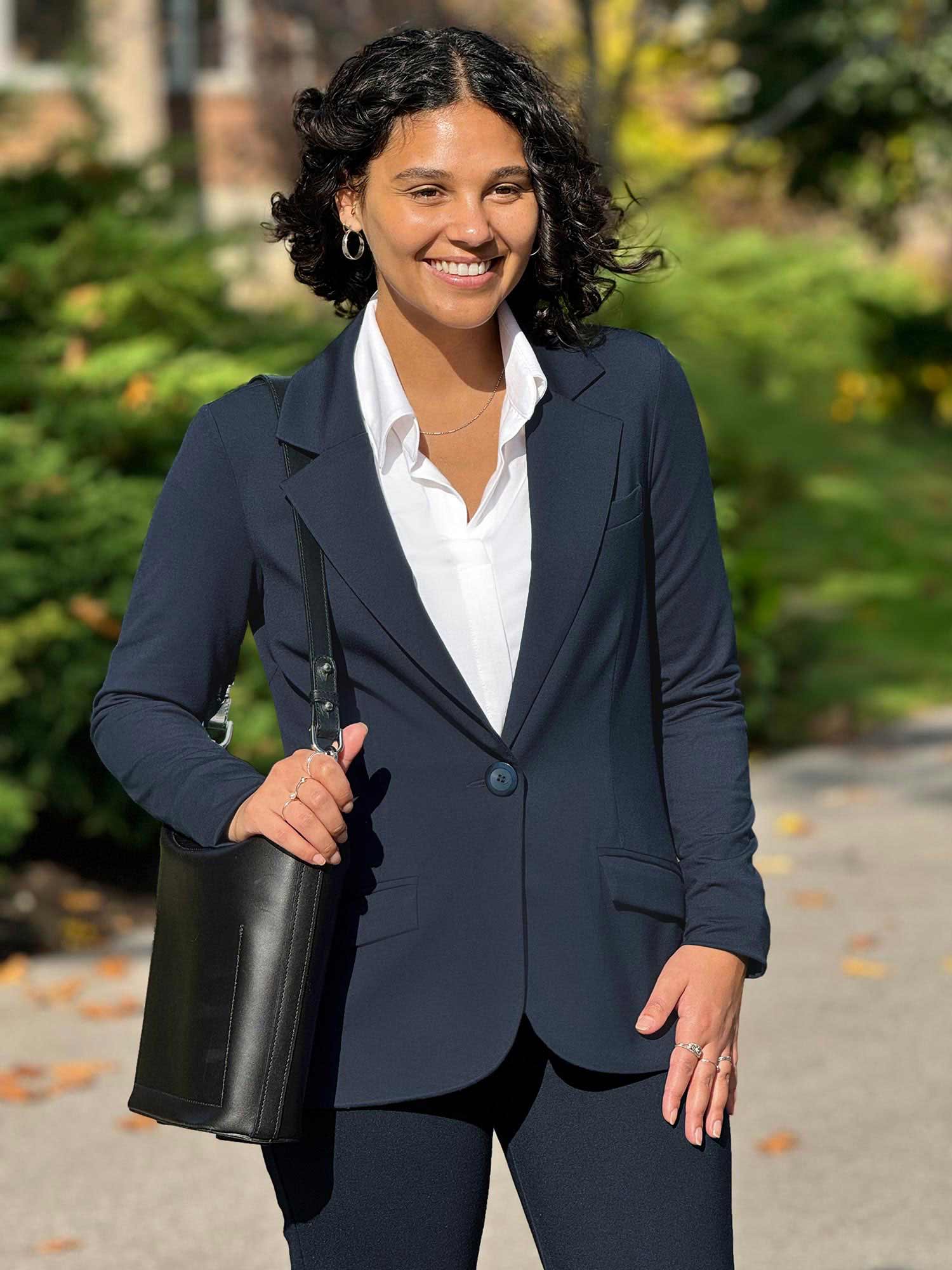 Woman standing wearing Miik's https://www.miik.ca/collections/all/products/sienna-relaxed-fit-stretchy-blazer in navy with matching pants