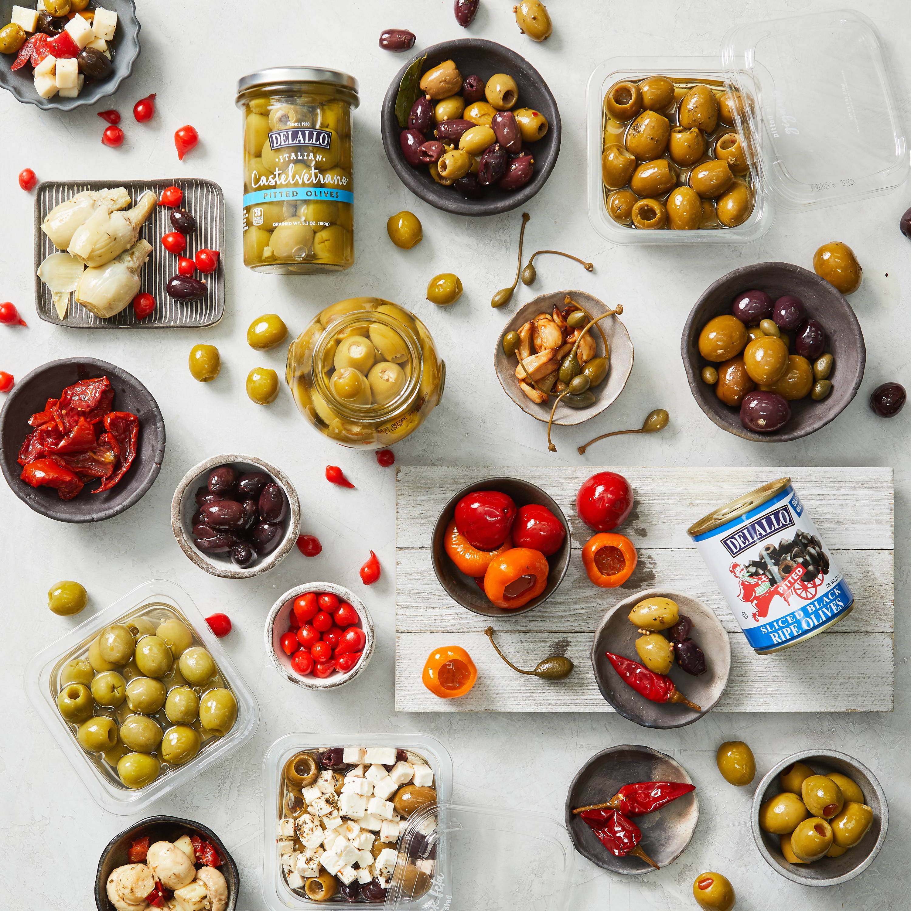 Assorted DeLallo olive and antipasti items arranged in packaging and bowls