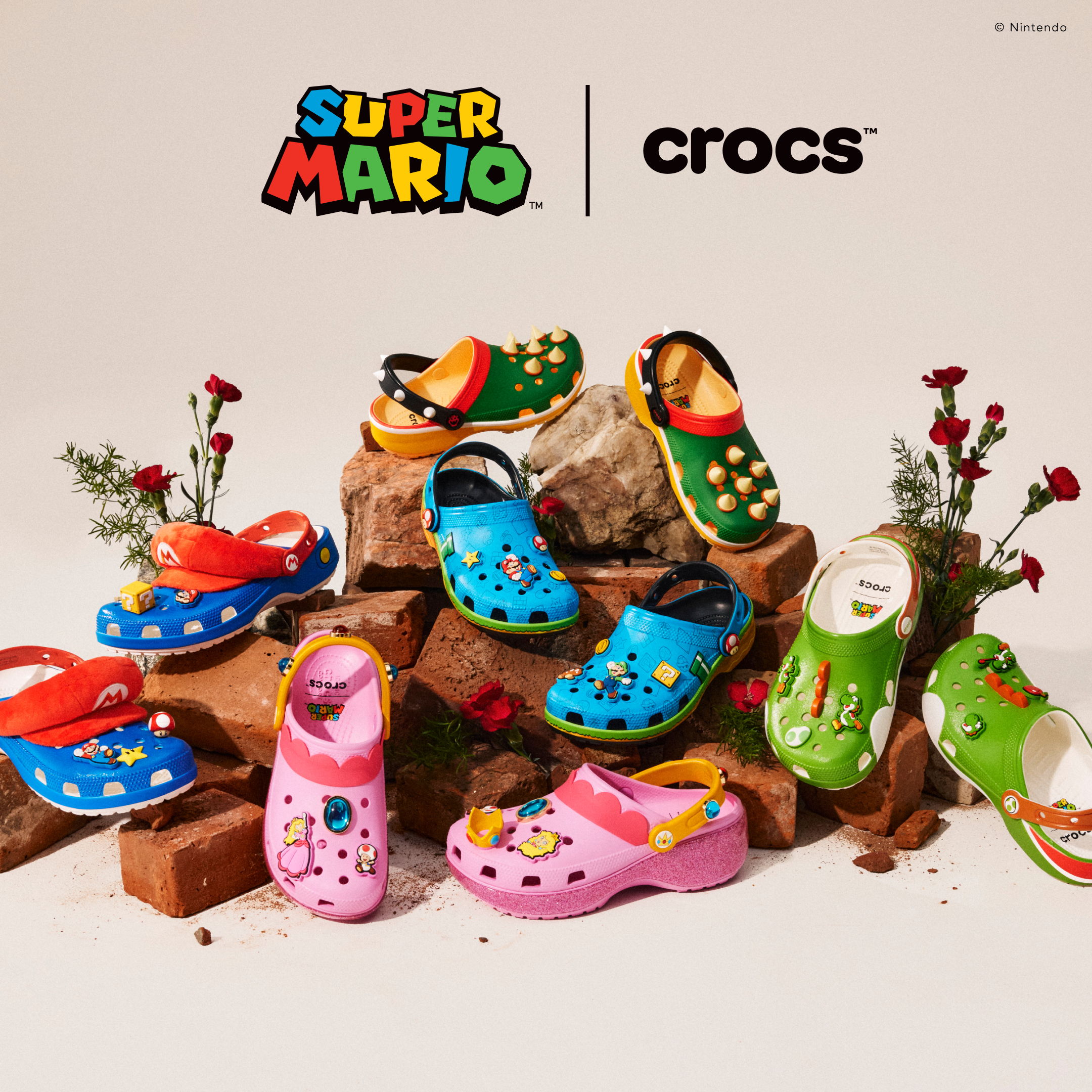 Super Mario-themed Crocs displayed on a decorative background with flowers.