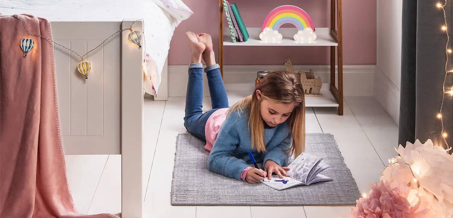 Young girls bedroom with illuminated fairy lights and rainbow light 