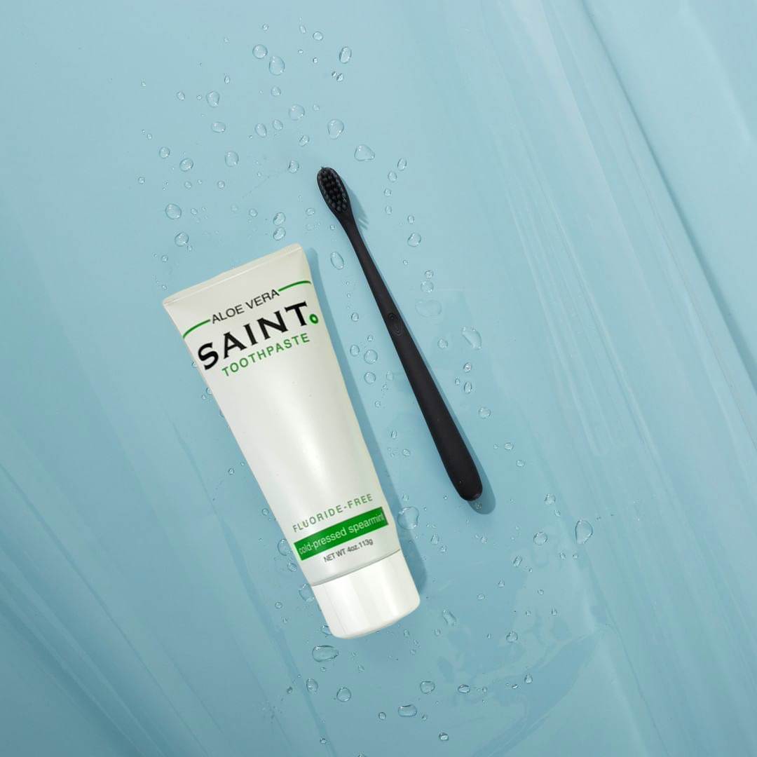 Saint fluoride-free toothpaste next to a toothbrush.