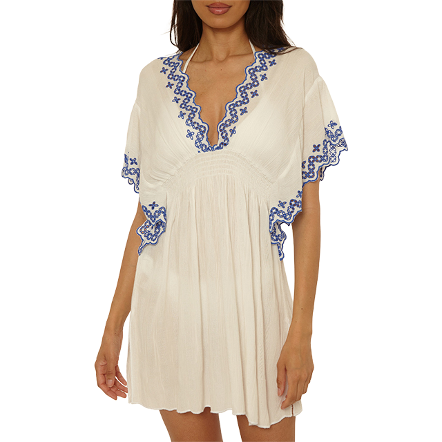 Woman in a white dress with blue embroidery details.