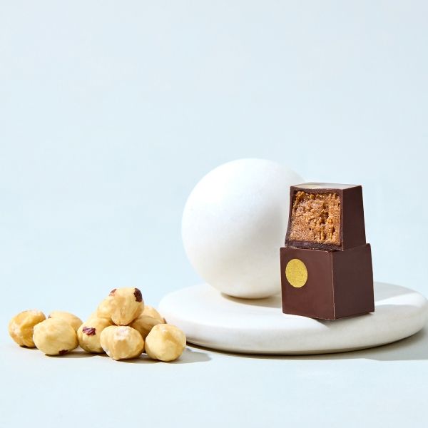 Chocolate piece, egg, and nuts arranged on a light background.