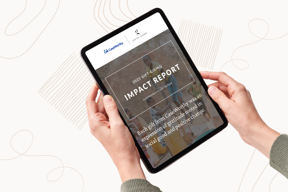 Person holding a tablet displaying an impact report webpage.