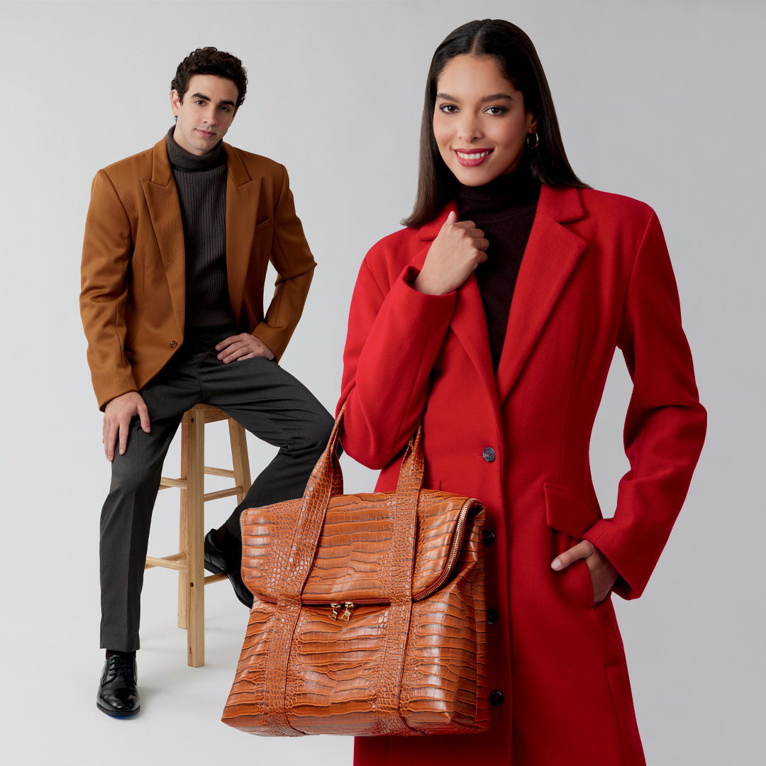 A man in a brown blazer and a woman in a red coat holding a bag.