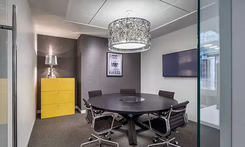 Modern conference room with a round table and stylish lighting.