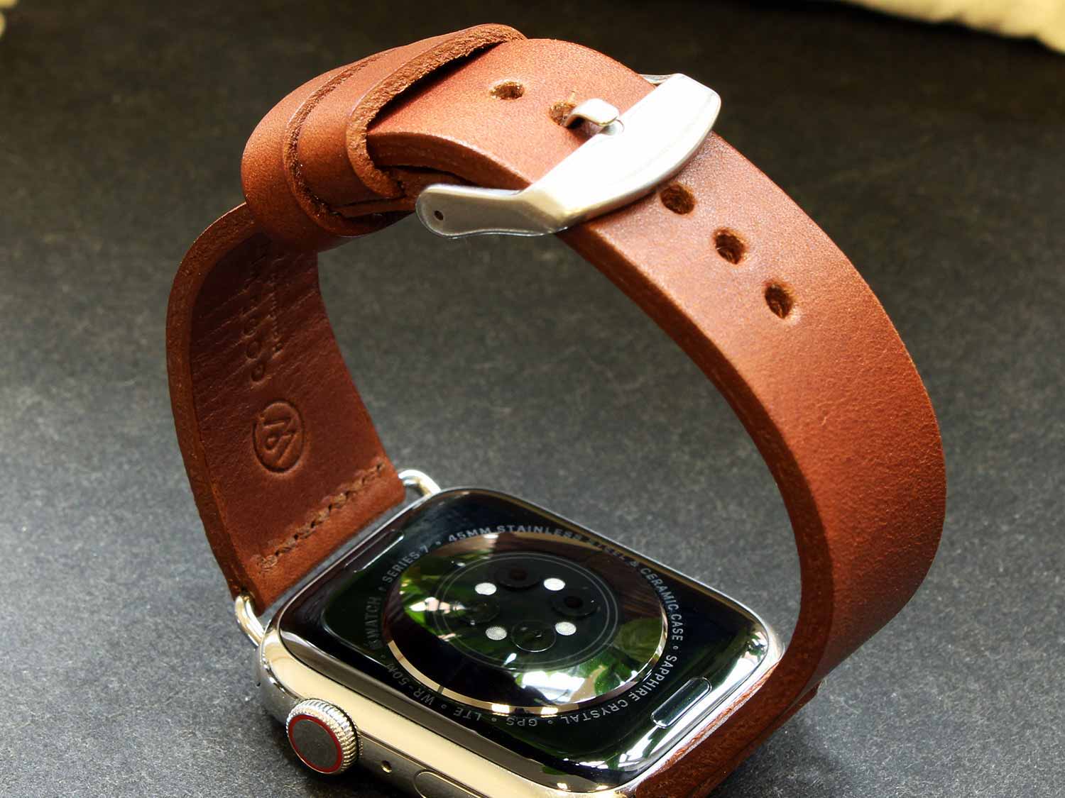 Eine Apple Watch mit Lederarmband in der Farbe Cognac liegt auf einem Tisch