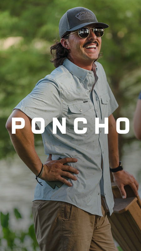 Man smiling outdoors, wearing sunglasses and a light blue shirt, with 
