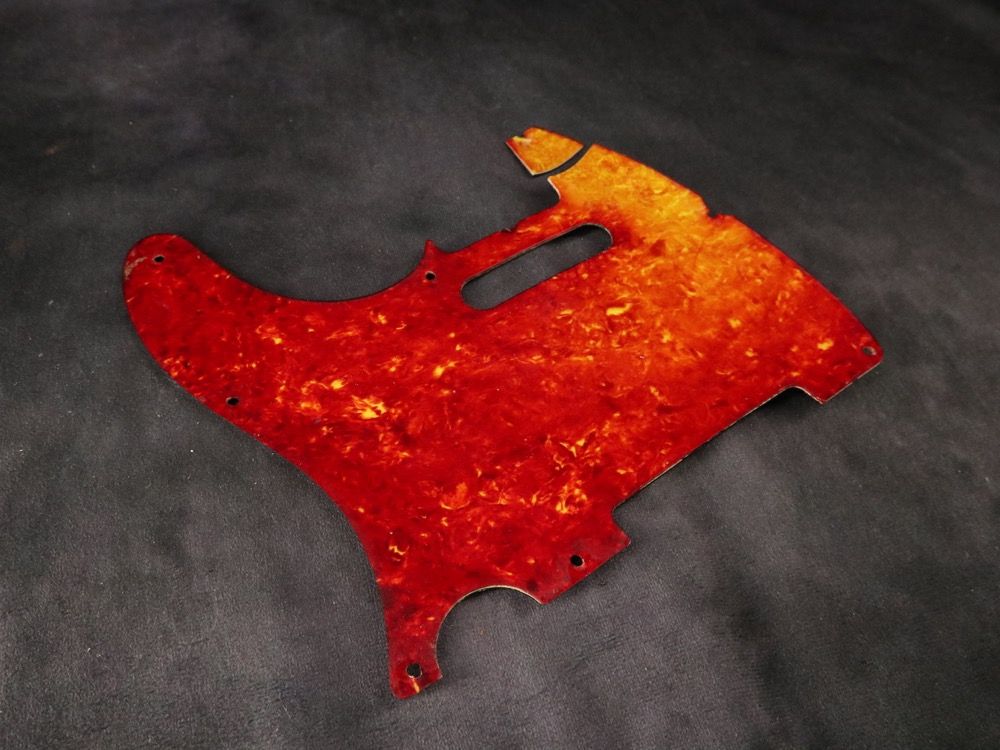 Colorful abstract art piece resembling a fragmented shape on a dark background.