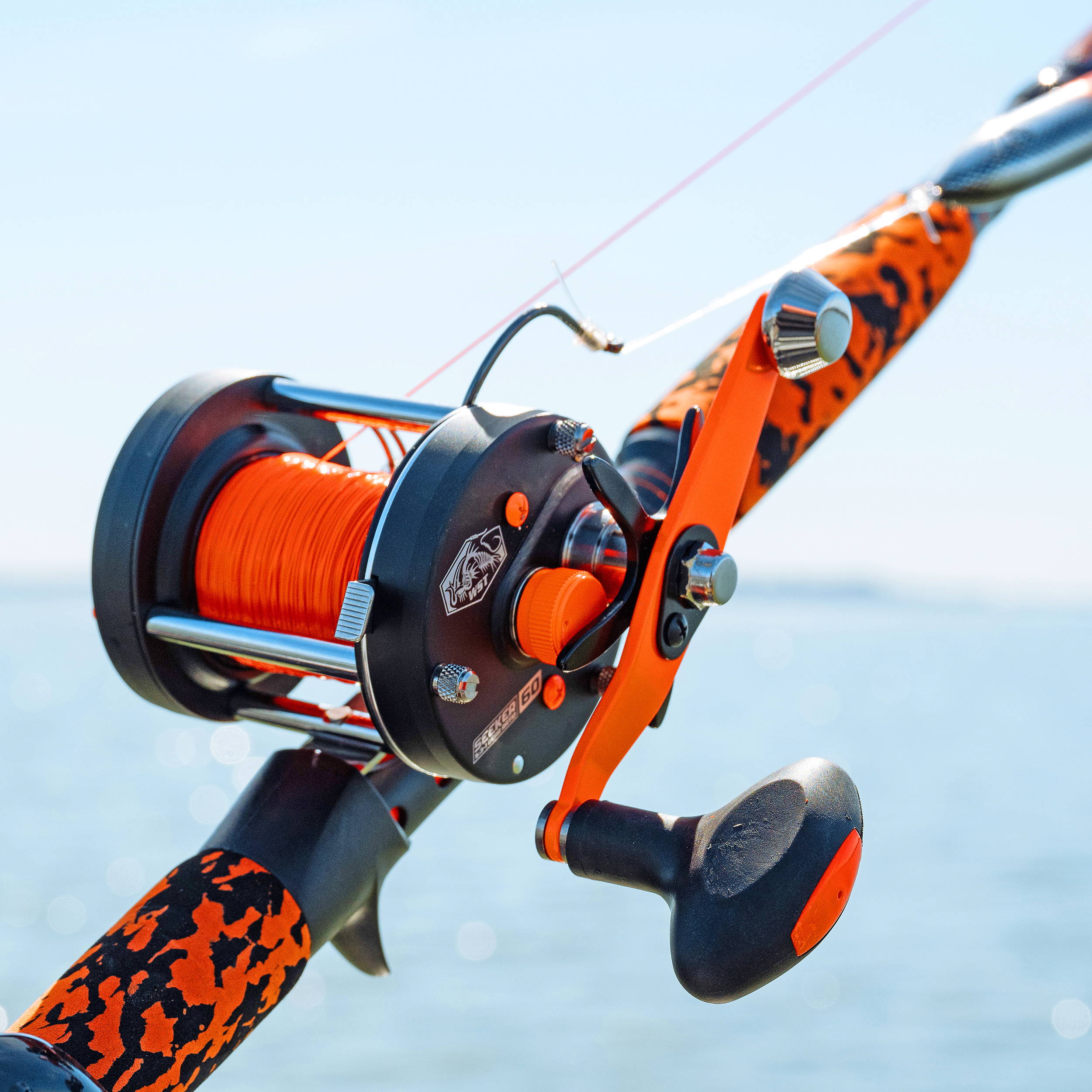 The Seeker 60 baitcast reel with the RAK kit in blaze orange outfitted on the Hog Seeker Catfish Rod.