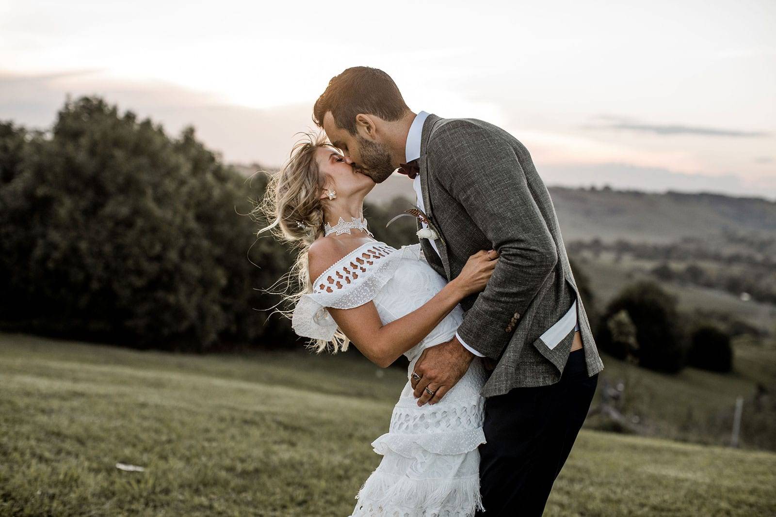 Grace Loves Lace bride kissing groom wearing the Coco Gown 