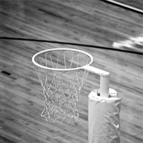 A basketball hoop viewed from above on a wooden court.