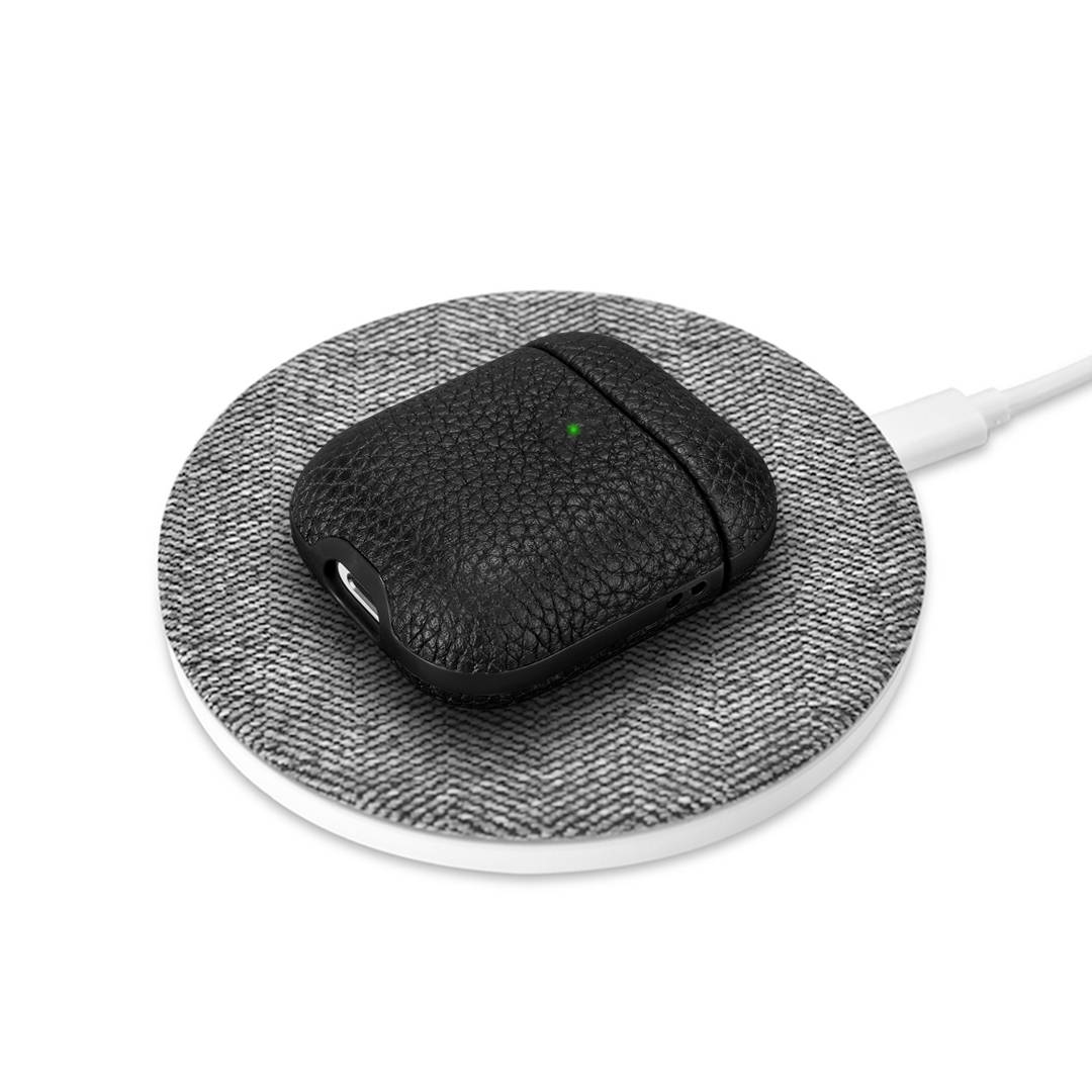 Best Black leather Airpods charging wirelessly on grey a ChargeMat wireless charging pad.