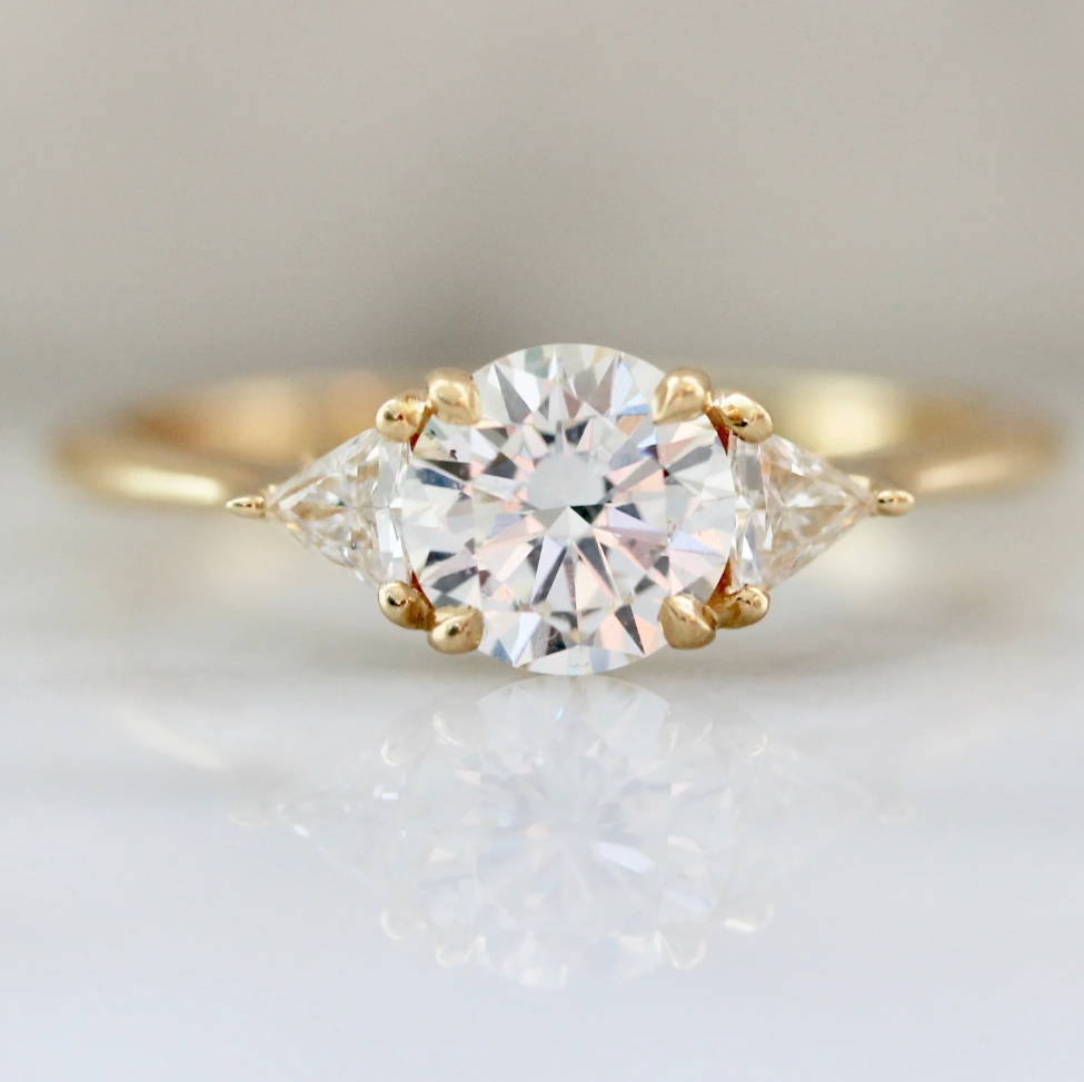 round brilliant diamond ring with trillion side stones