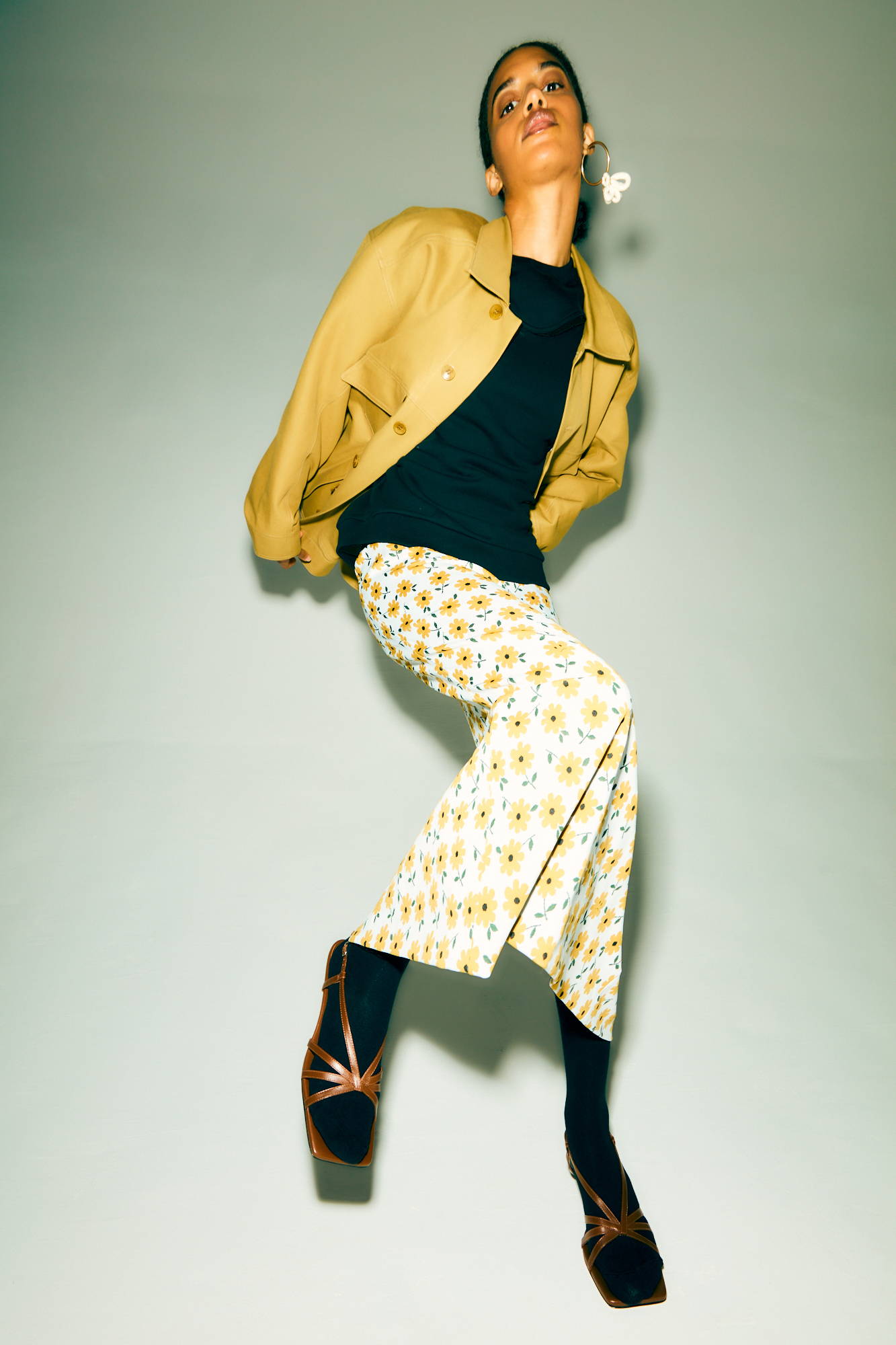 A model poses in stylish clothing against a simple background.