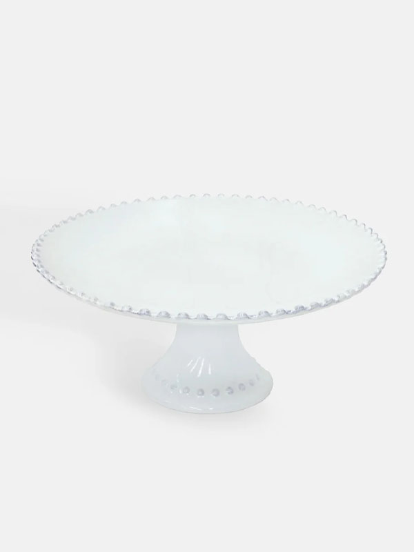 White glass cake stand with a scalloped edge and pedestal base.