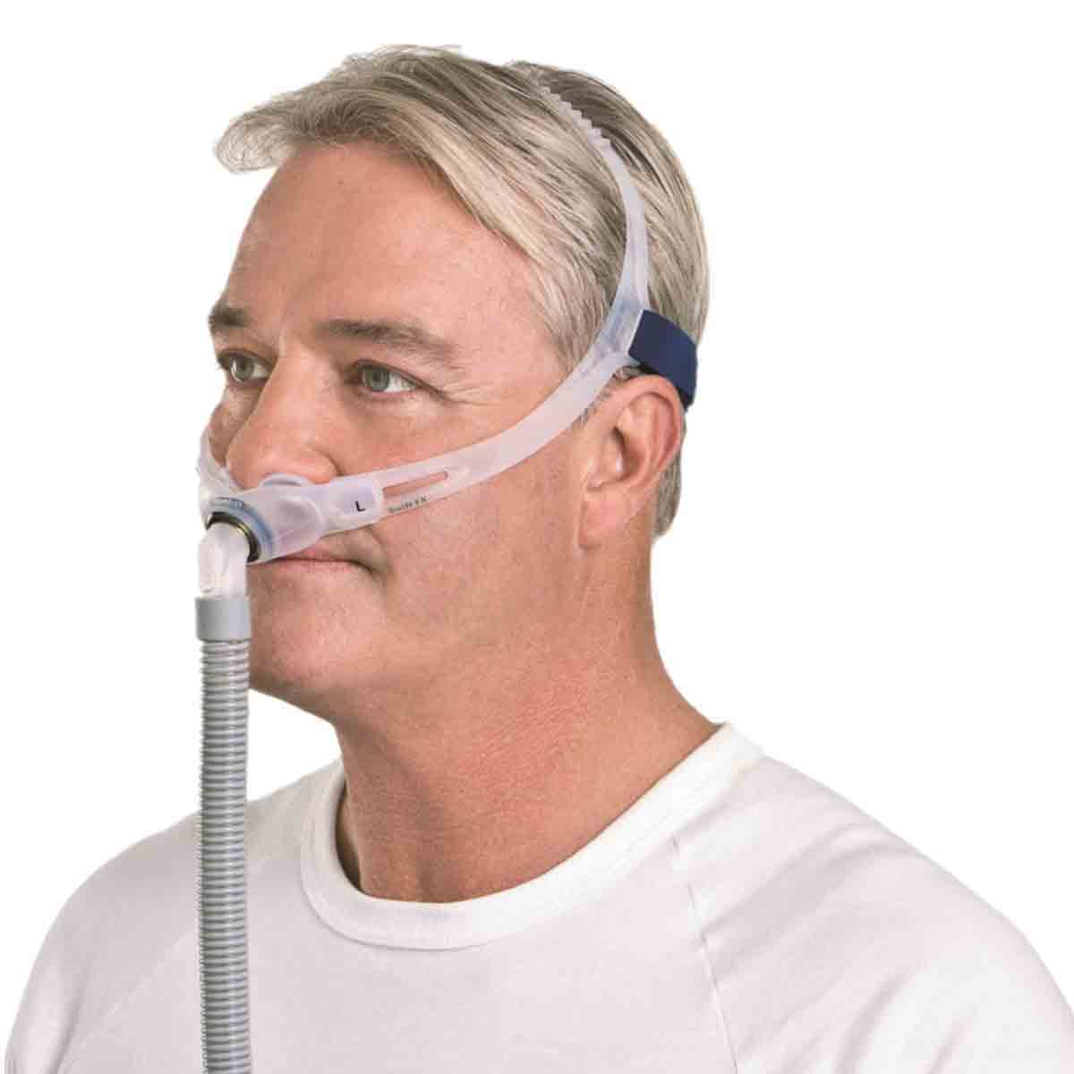 Stock photo of man wearing ResMed Swift FX nasal pillow CPAP mask with headgear