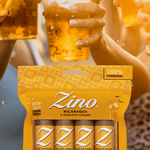 Ein freshpack mit Zino Nicaragua Robusto-Zigarren vor einem Hintergrund mit Leuten, die mit Bier anstossen. 