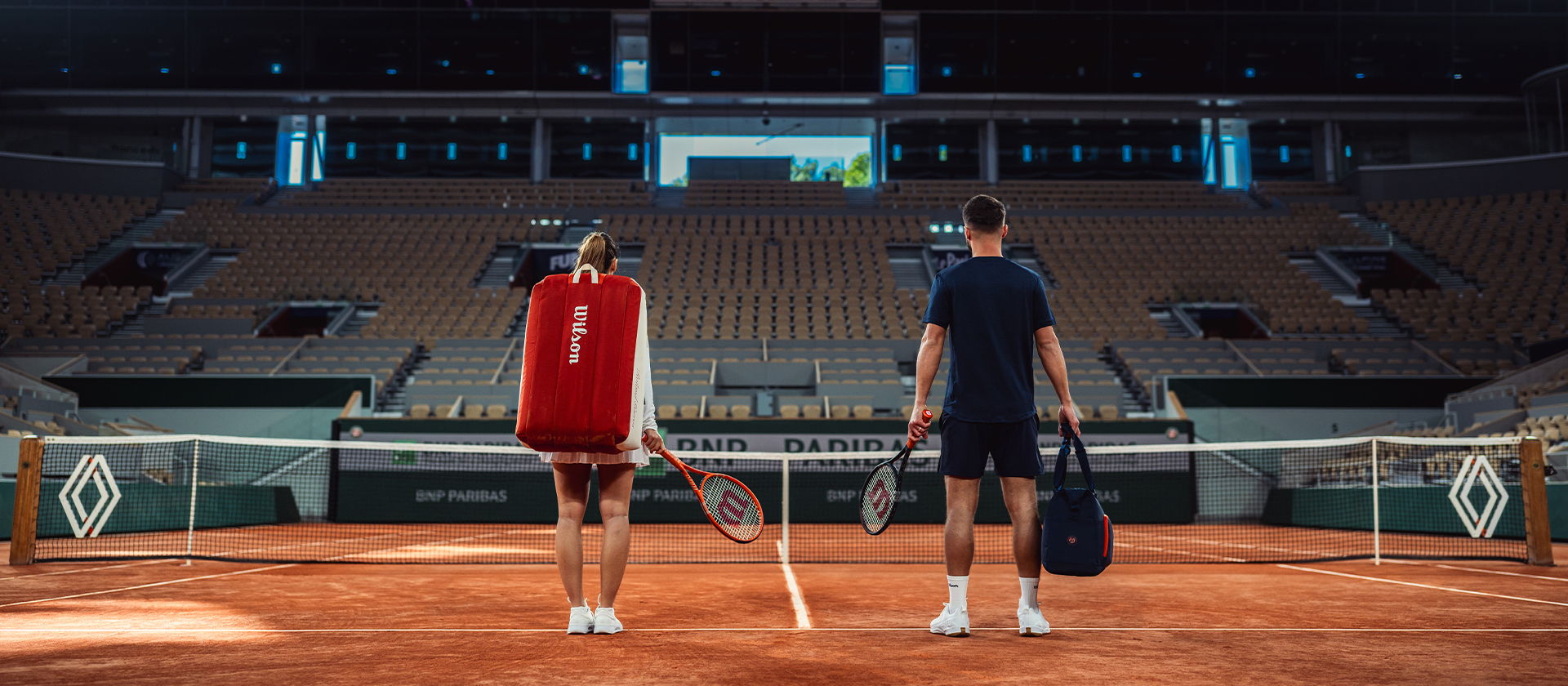 Two tennis players in an empty stadium, preparing for a match.