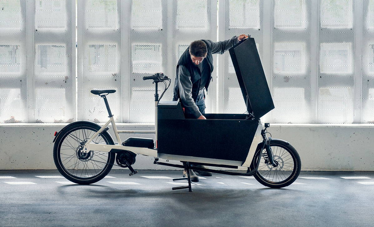 A man leans into the box of a Riese & Muller Transporter2 85 e-cargo bike