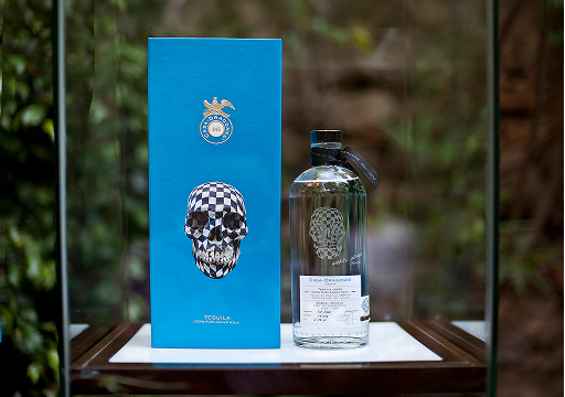 Bottle of liquor with a blue box featuring a skull design.