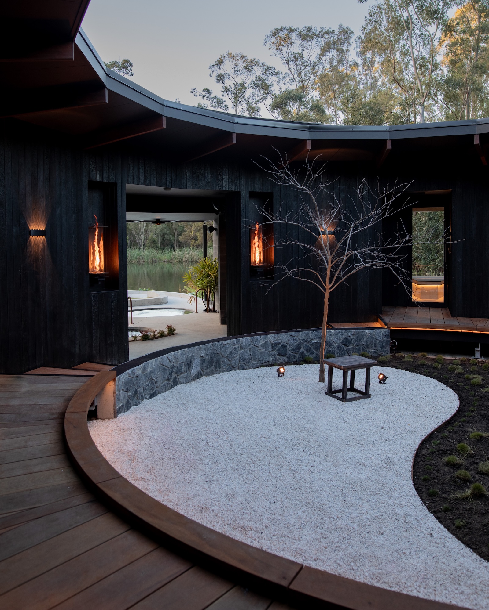 Modern Japanese style interior with curved walls, minimalist wall lights, and a tranquil garden.