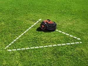 A robotic lawn mower on grass with an illustration showing random cutting pattern