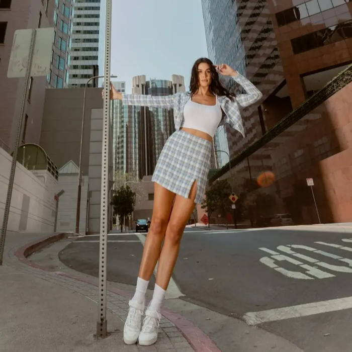 female model wearing white adidas forum shoes in the city