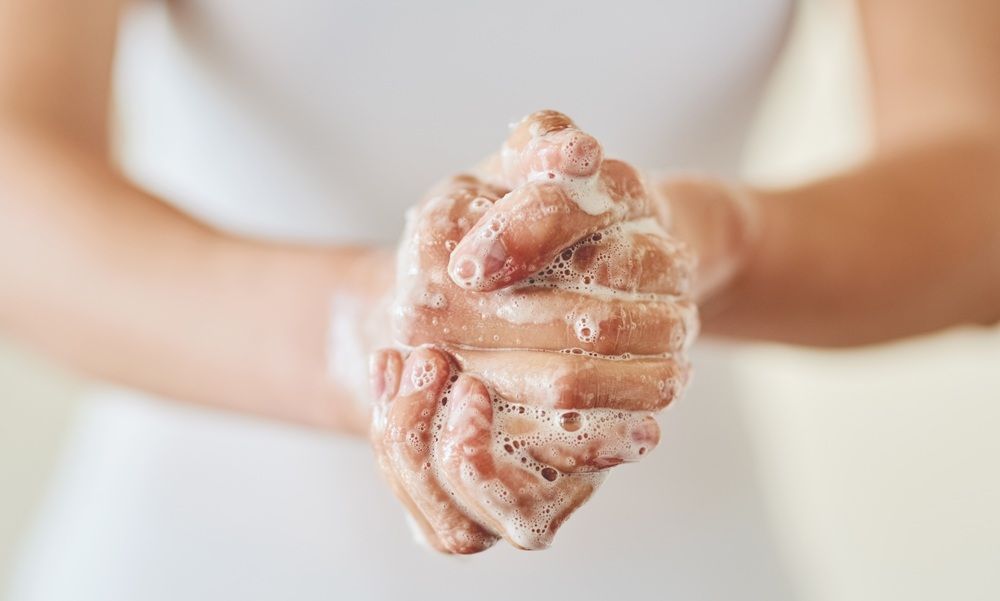 Person washing hands with soap, focusing on lathering.