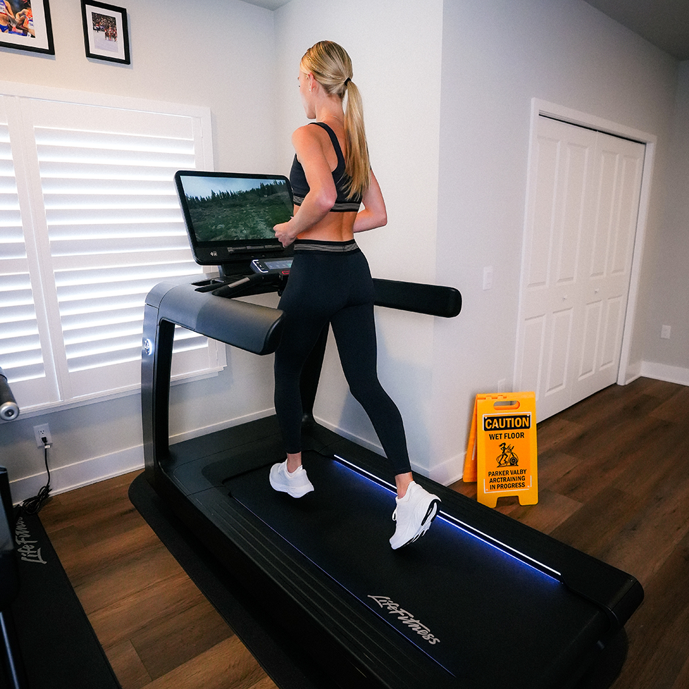 Parker Valby running on a treadmill in a home gym setting.