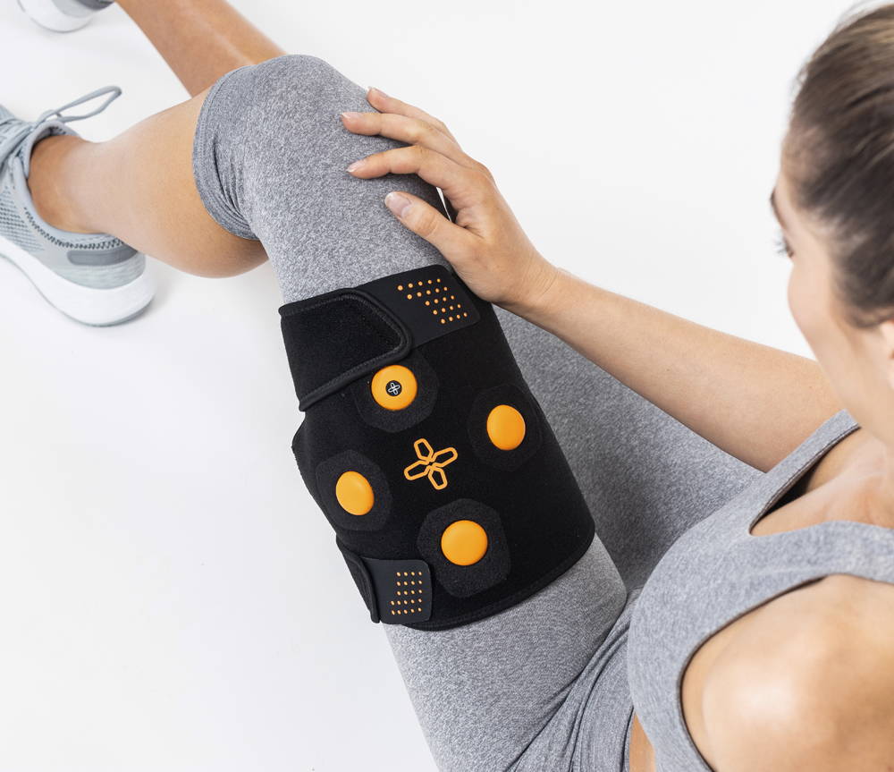 Myovolt wearable vibration therapy leg device wraps around the thigh to treat muscle pain and stiffness in quads and hamstrings. Athlete recovery tech to rejuvenate overworked leg muscles after exercise.