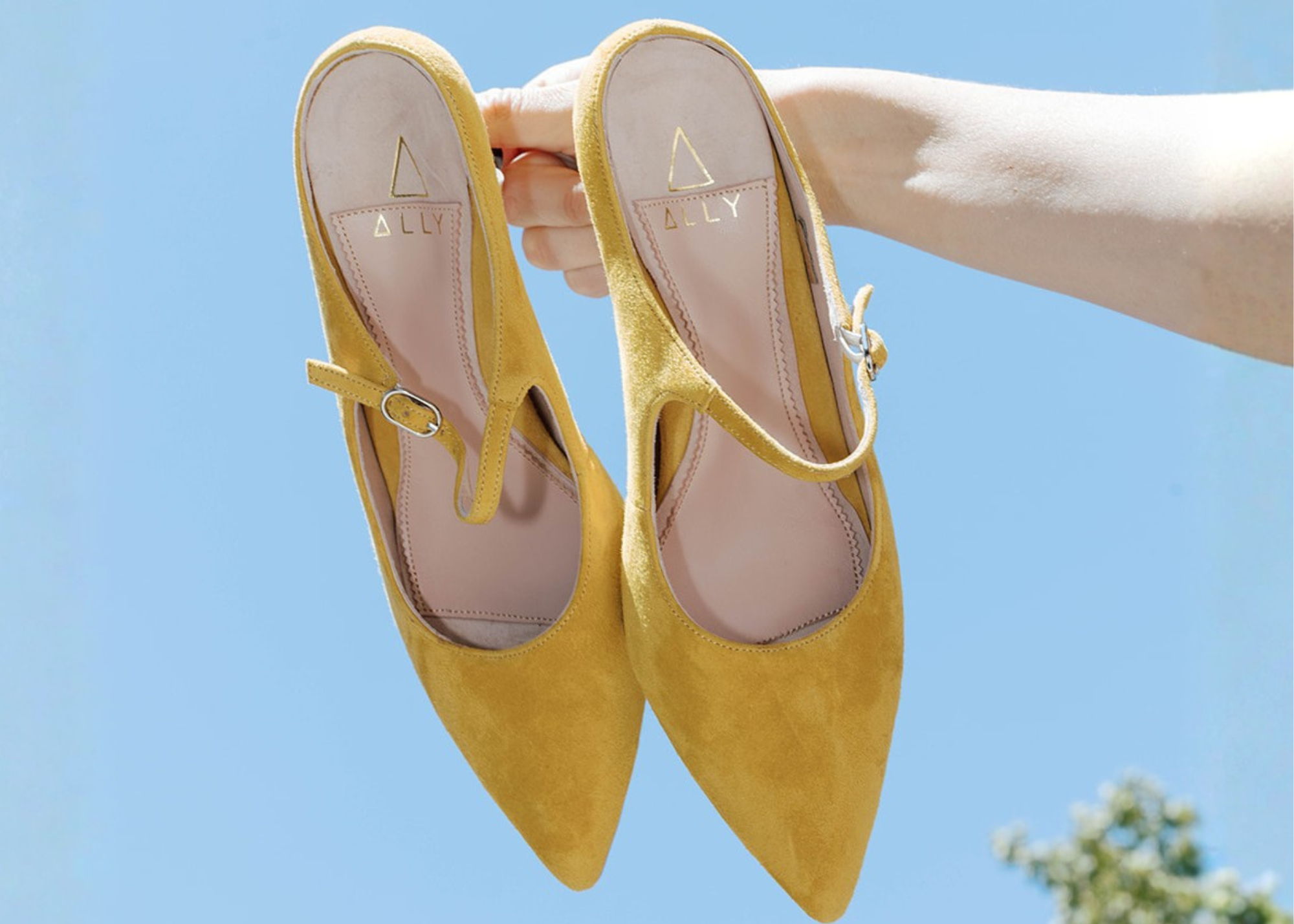 Yellow suede slingback high heel shoe with a strap.