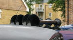 Close-up four glossy black Shocker XL train horn trumpets mounted on silver roof residential background Will's 1993 Eurovan gallery photo 2