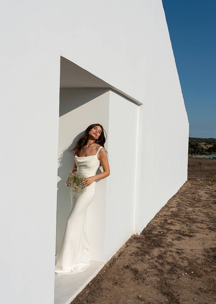Model standing up against a wall wearing the Grace gown
