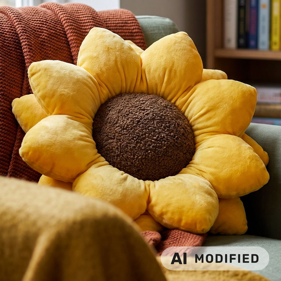 Un coussin en forme de tournesol sur un canapé avec un plaid douillet.