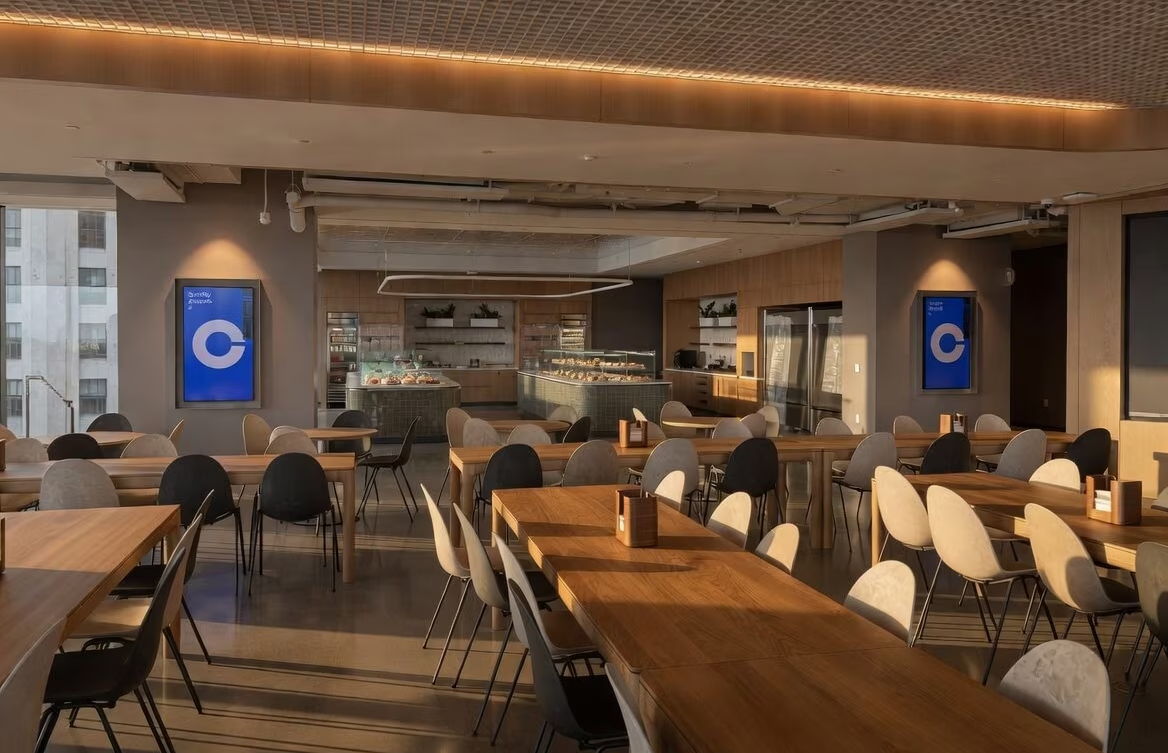 Modern restaurant interior with wooden tables and sleek seating arrangements.