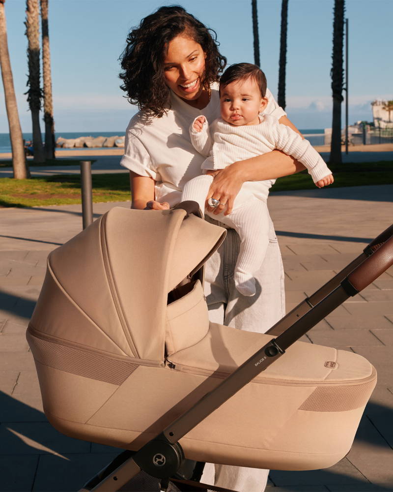 Woman holding baby infront of the Cybex Balios S Lux