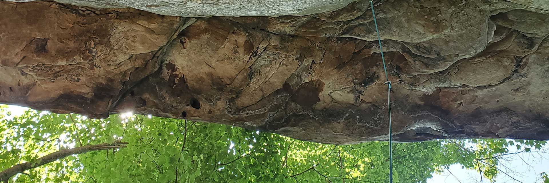 Looking up at a rock overhang with rope