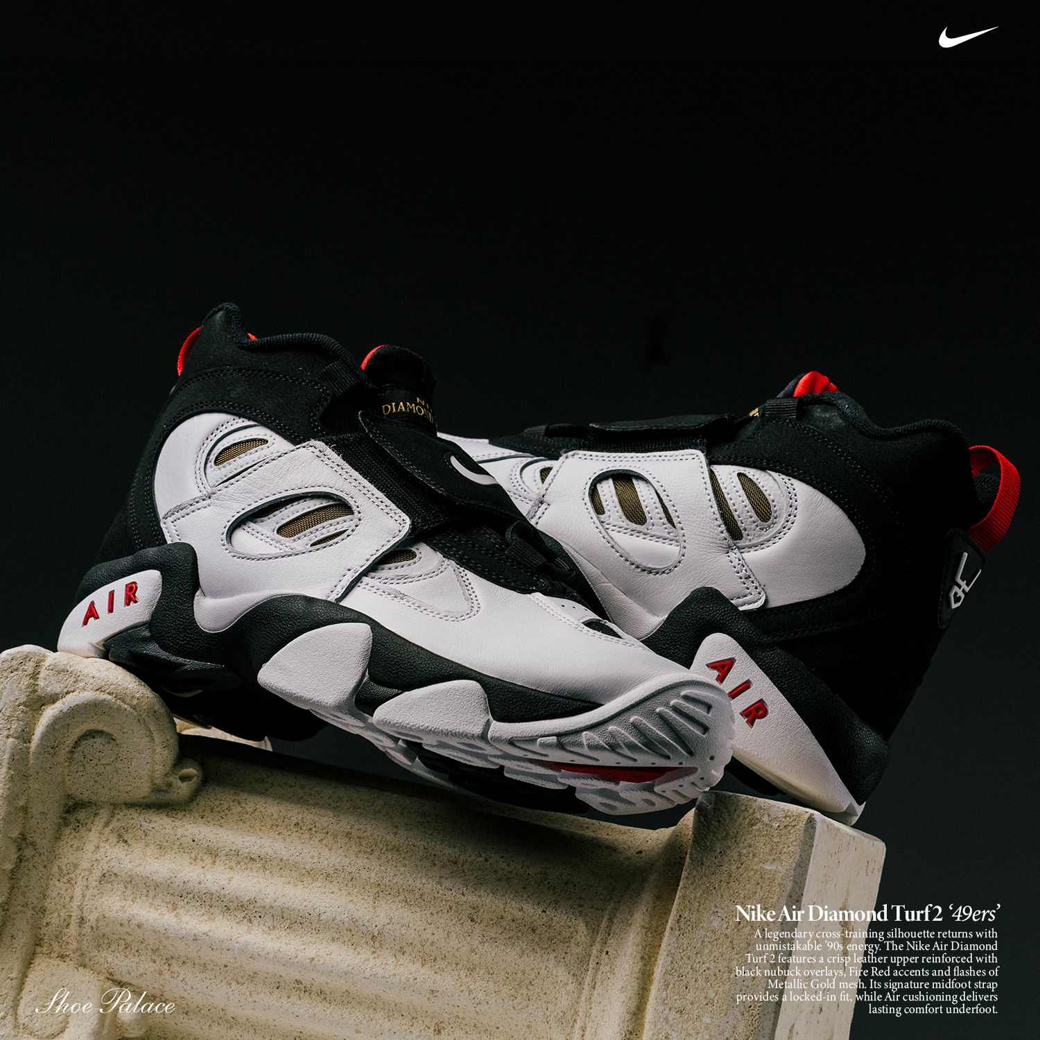 A pair of Nike basketball shoes on a pedestal against a dark background.