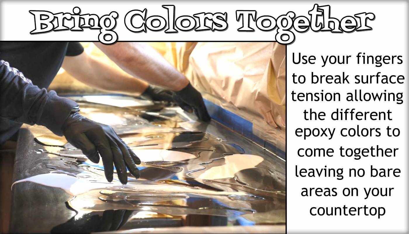 Use your fingers to break surface tension, allowing the different epoxy colors to blend, leaving no bare areas on your countertop.