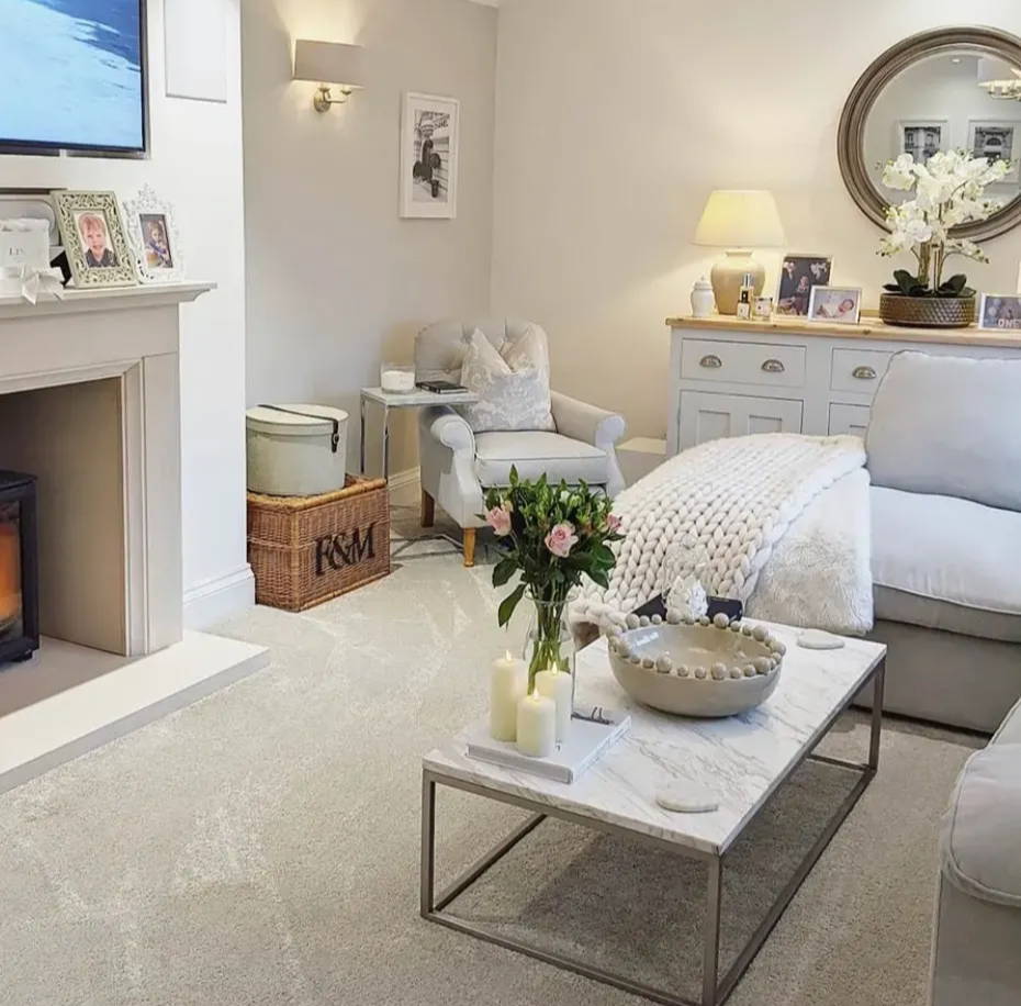 Cosy lounge setting with illuminated candles on coffee table. 