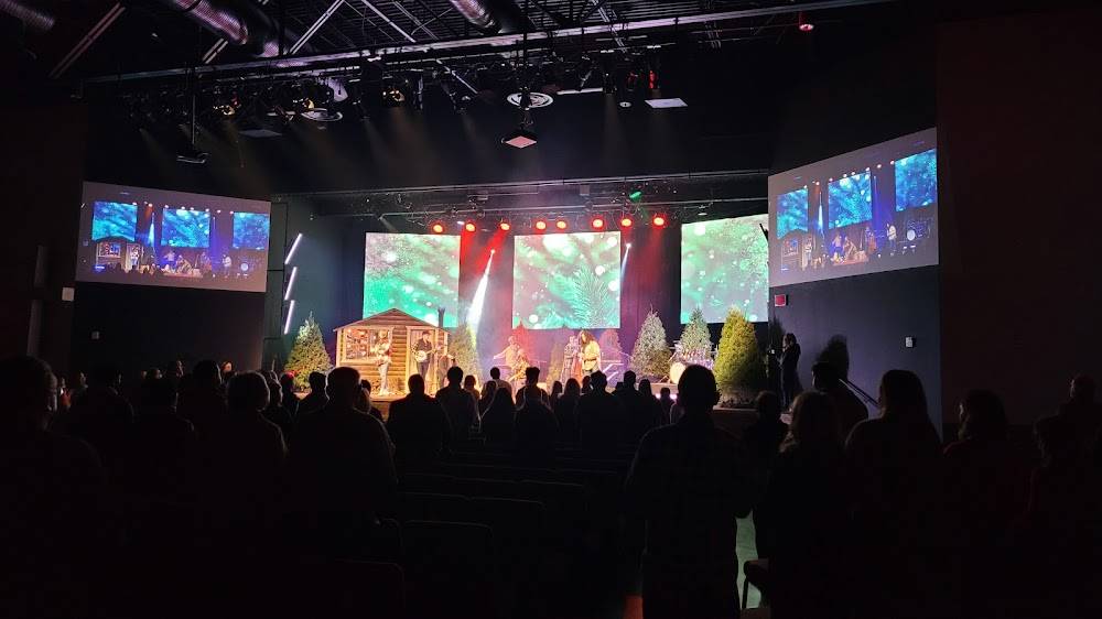 Congregation watching a service on large LED screens with stage lighting
