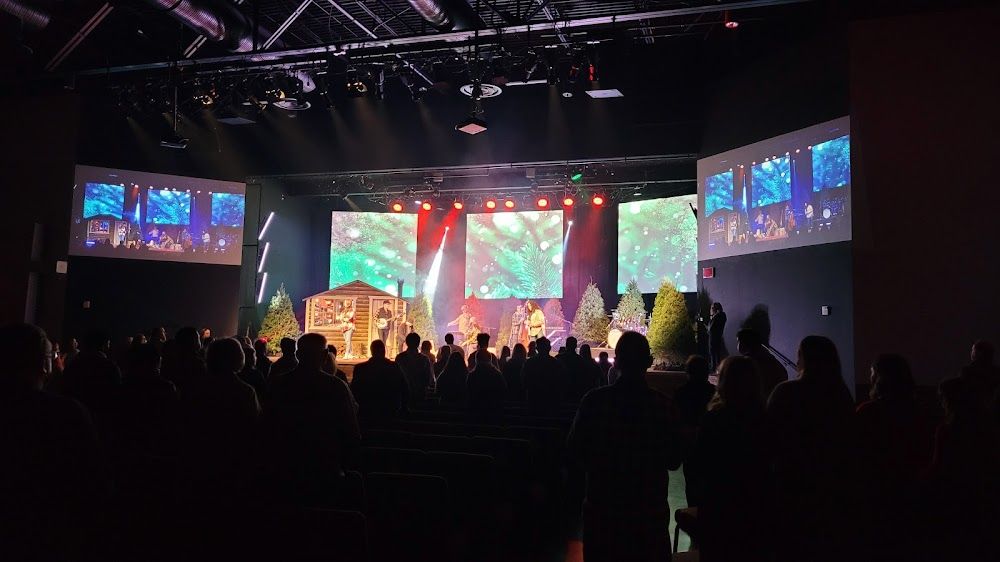 Audience watching a performance with colorful screens and stage lighting.