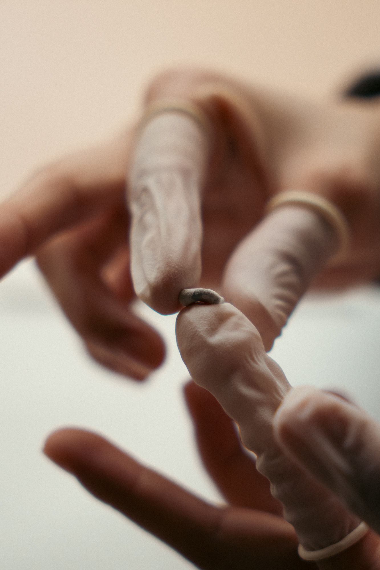 A person in gloves holding a small object between their fingers.